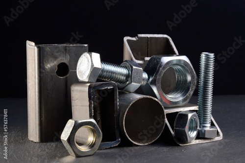 composition of nuts bolts and scraps of metal laid out on a dark background.