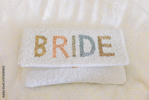 A bride's white clutch with the words 