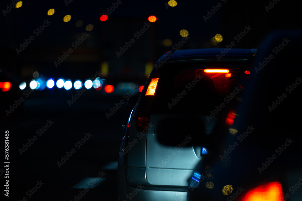 Cars in night traffic jams at highway exit. View of the vehicles from the driver's perspective Cars in night traffic jams at highway exit. View of the vehicles from the driver's perspective