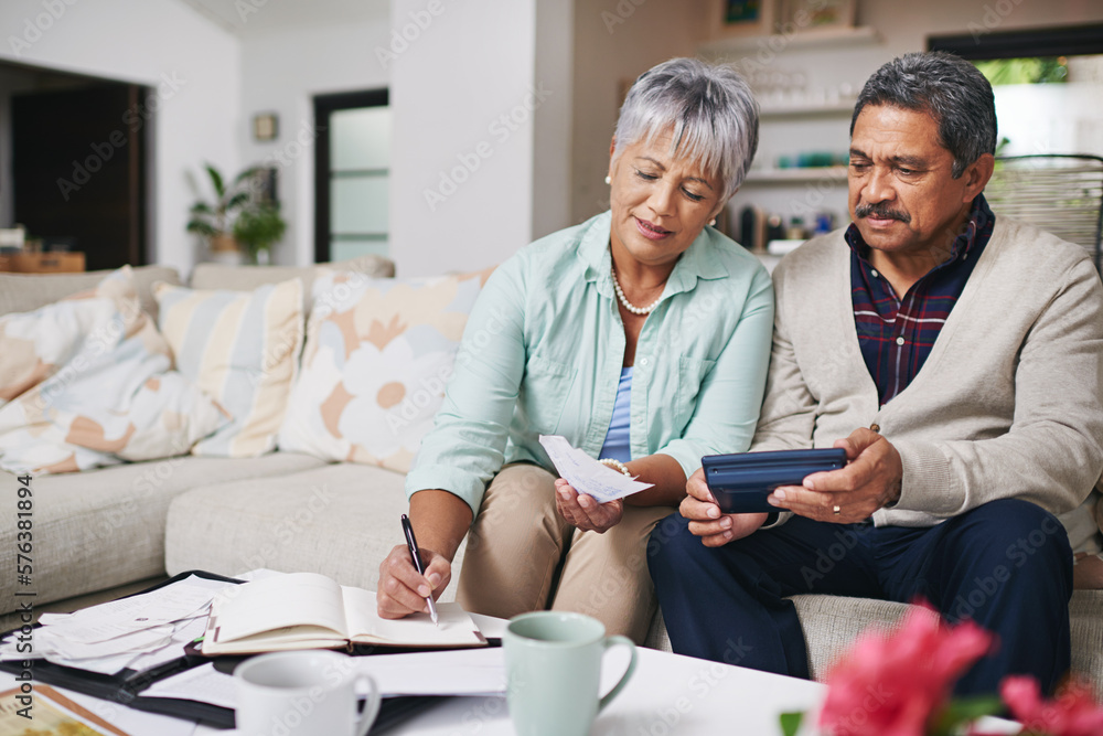 Budgeting works better when we do it together. Shot of an elderly couple working out a budget while sitting on the living room sofa. Budgeting works better when we do it together. Shot of an elderly couple working out a budget while sitting on the living room sofa.