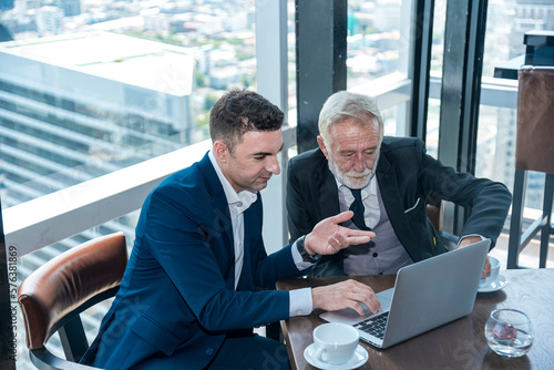 businessman talking and explane business deal  at skyscraper office lounge with cityscape business zone background © lukyeee_nuttawut