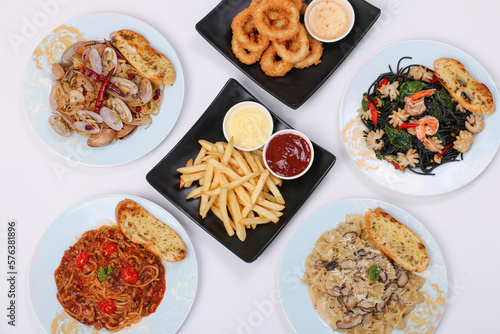 set of various plates of food, pasta dishes, onion ring, french fried, isolated on white background, top view.
