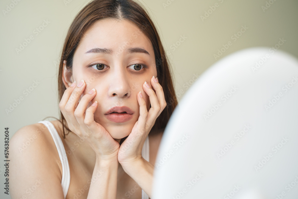 lack of sleep problem, Worried Asian young woman pointing finger at dark circles under her eyes lack of sleep problem, Worried Asian young woman pointing finger at dark circles under her eyes