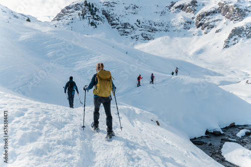 group of mountaineers doing a route with snowshoes in winter on a sunny day in the pyrenees