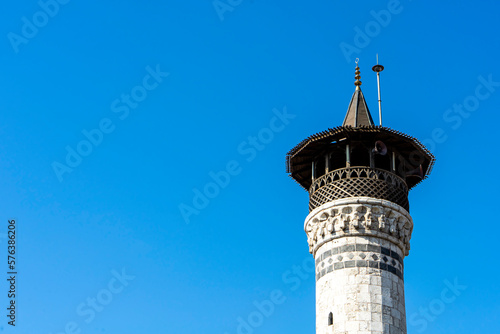 Minaret of historical Habibi Neccar Mosque in Antakya (Hatay) Turkey, on the background of blue sky before the earthquake of 2023. Copy space for text. photo