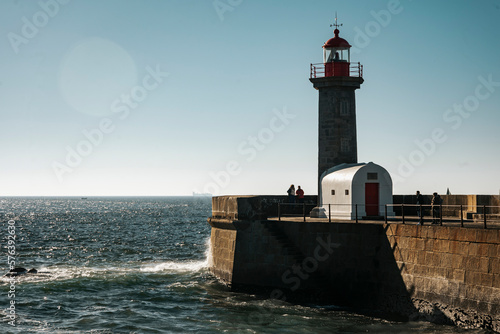 Horizontal view of the sunset at the Felgueira lighthouse at Foz do Douro, view of the dark blue sea. Porto, Portugal