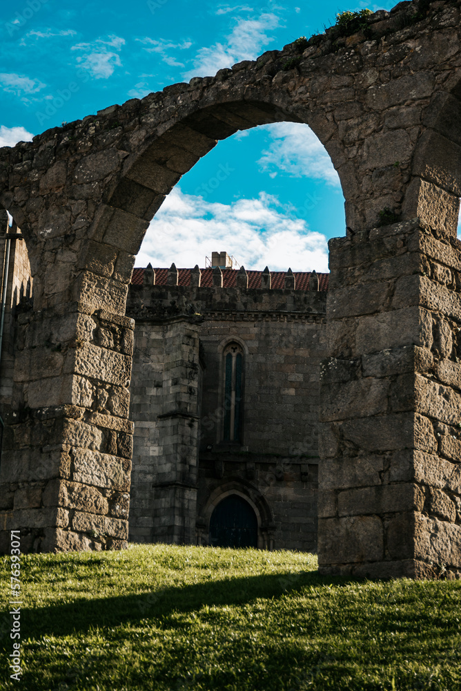 Part of the gothic stone monastery of Santa seen between the arches of the aqueduct, Vila do Conde, Portugal,