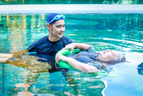 Asian man or physiotherapist helping elderly female patient with hydrotherapy It is a rehabilitation and exercise in the water. physical therapy center