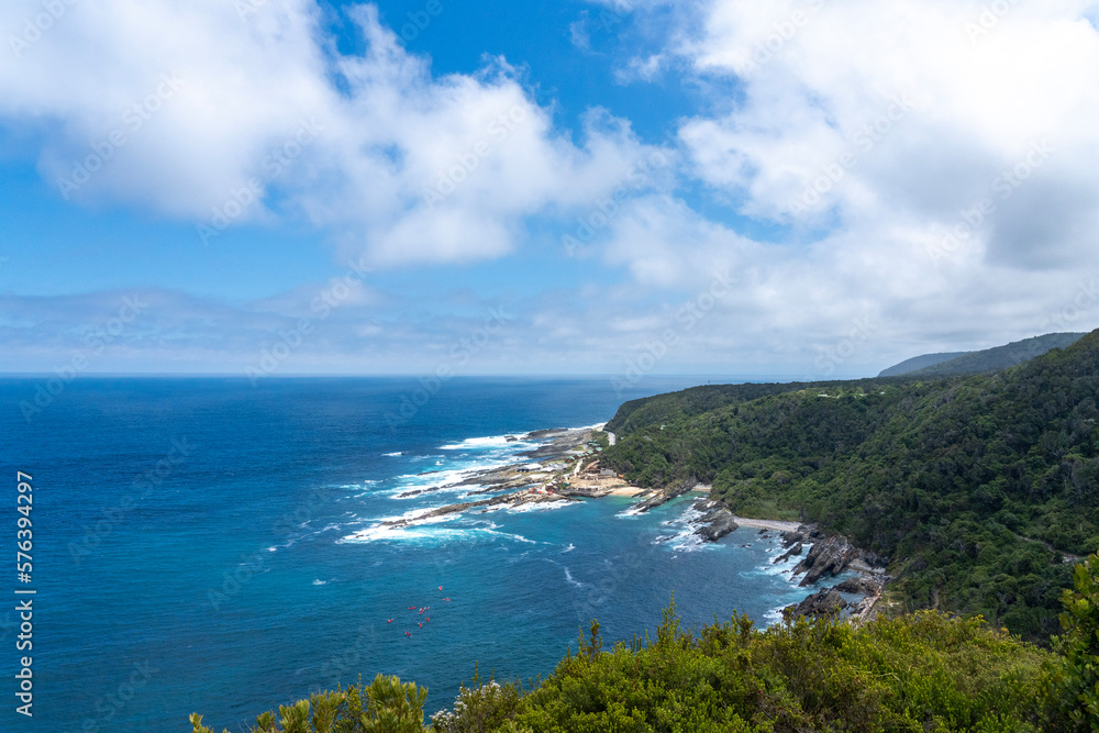 view of coastline with Blue turquoise water and green forests on the coast of south africa 