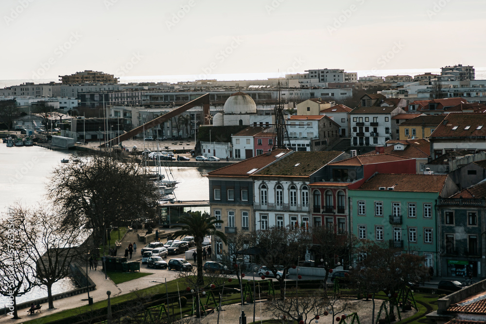 View from a distance of the buildings on the banks of the Ave river in the late afternoon in Vila do Conde, Portugal