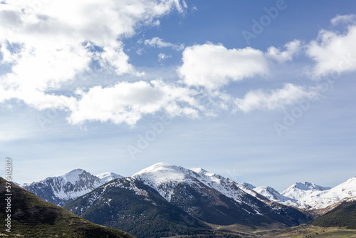 Paisaje montañoso de un valle y montañas nevadas al fondo