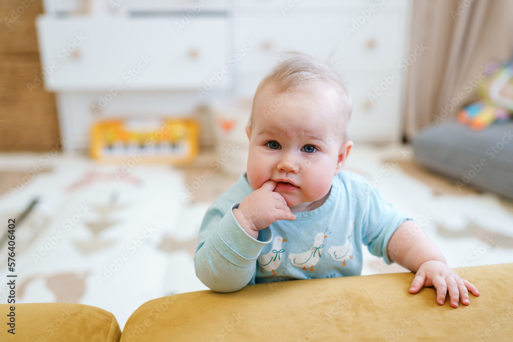 Portrait of a cute cheerful baby toddler and a baby synthesizer in the background