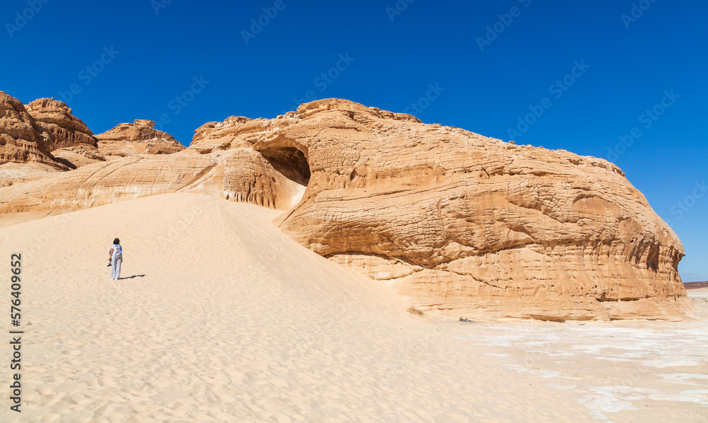 Dahab, Sinai peninsula, Egypt - January 2022: Unrecognizable Young woman and Dragon mountain in Sinai desert. Dahab, Sinai peninsula, Egypt - January 2022: Unrecognizable Young woman and Dragon mountain in Sinai desert.