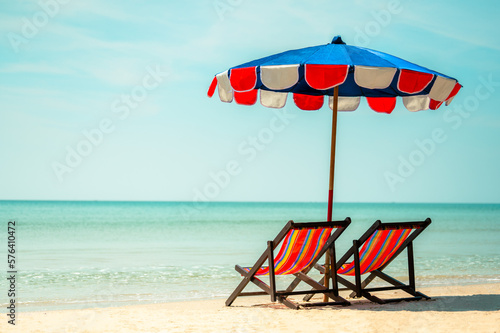 Two colorful deck chair and colorful an umbrella.tropical sandy beach, summer travel, vacation and summer holiday concepts.