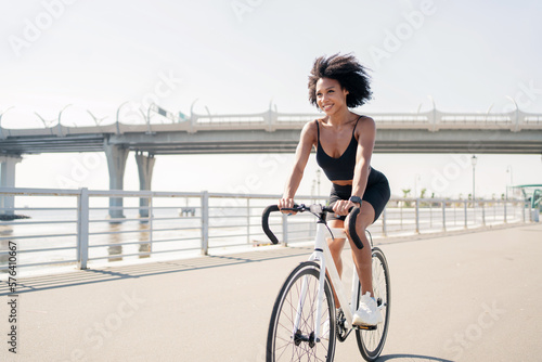 Sporty woman happy cyclist for fitness training bike, hobby active outdoor workout. Healthy lifestyle and fitness suit for training.