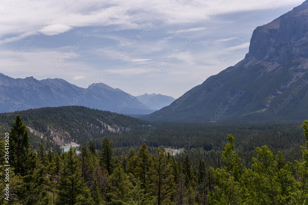 Natural landscape - Bow River Valley, Rocky Mountains, coniferous forest and beautiful sky with clouds. Summer tourism in the mountains