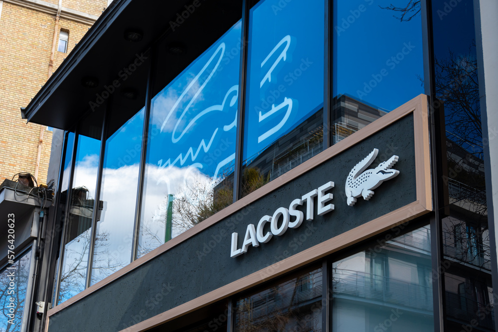 Stockfoto med beskrivningen Boulogne-Billancourt, France - 28 février 2023:  Vue extérieure d'une boutique Lacoste, entreprise française spécialisée  dans la conception et la vente de vêtements, chaussures, accessoires et  parfums | Adobe Stock