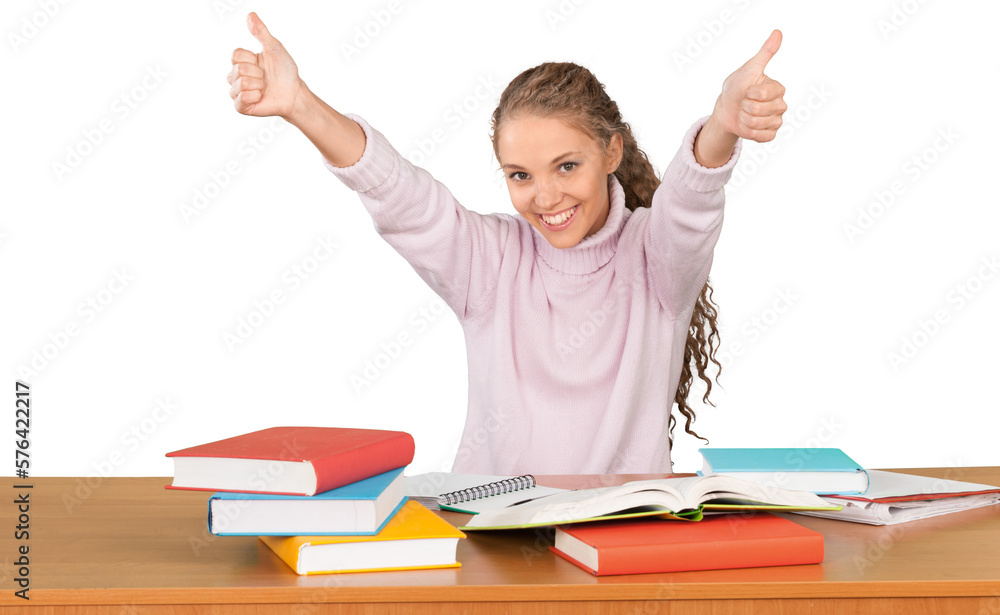 Friendly Girl Sitting Behind a Desk with a Books and Thumbs Up - Isolated Friendly Girl Sitting Behind a Desk with a Books and Thumbs Up - Isolated