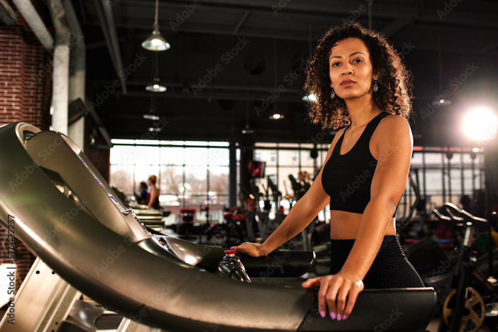 African American woman running on a treadmill in the gym. African American woman running on a treadmill in the gym.