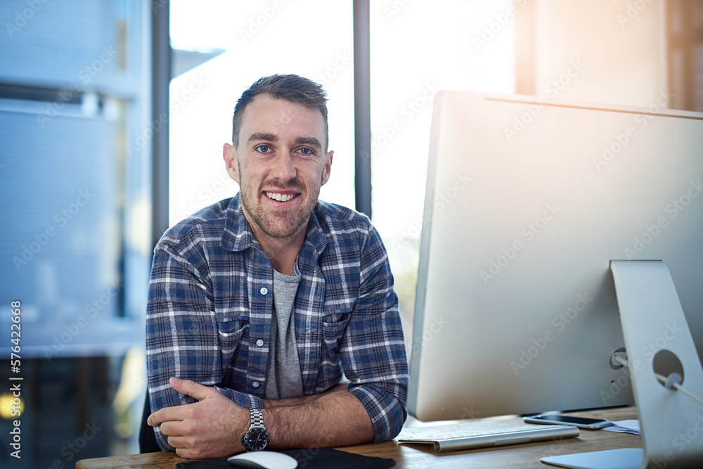 Doing what I love and making money from it. Portrait of a happy young businessman working at his office desk. Doing what I love and making money from it. Portrait of a happy young businessman working at his office desk.