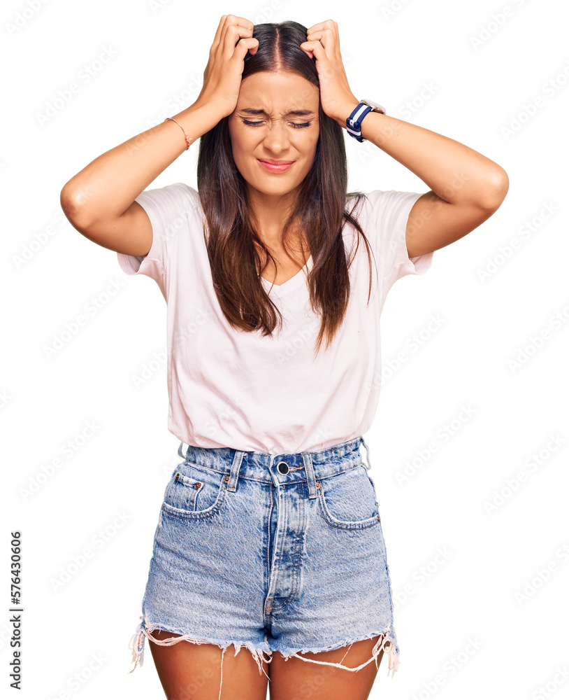 Young hispanic woman wearing casual white tshirt suffering from headache desperate and stressed because pain and migraine. hands on head. Young hispanic woman wearing casual white tshirt suffering from headache desperate and stressed because pain and migraine. hands on head.