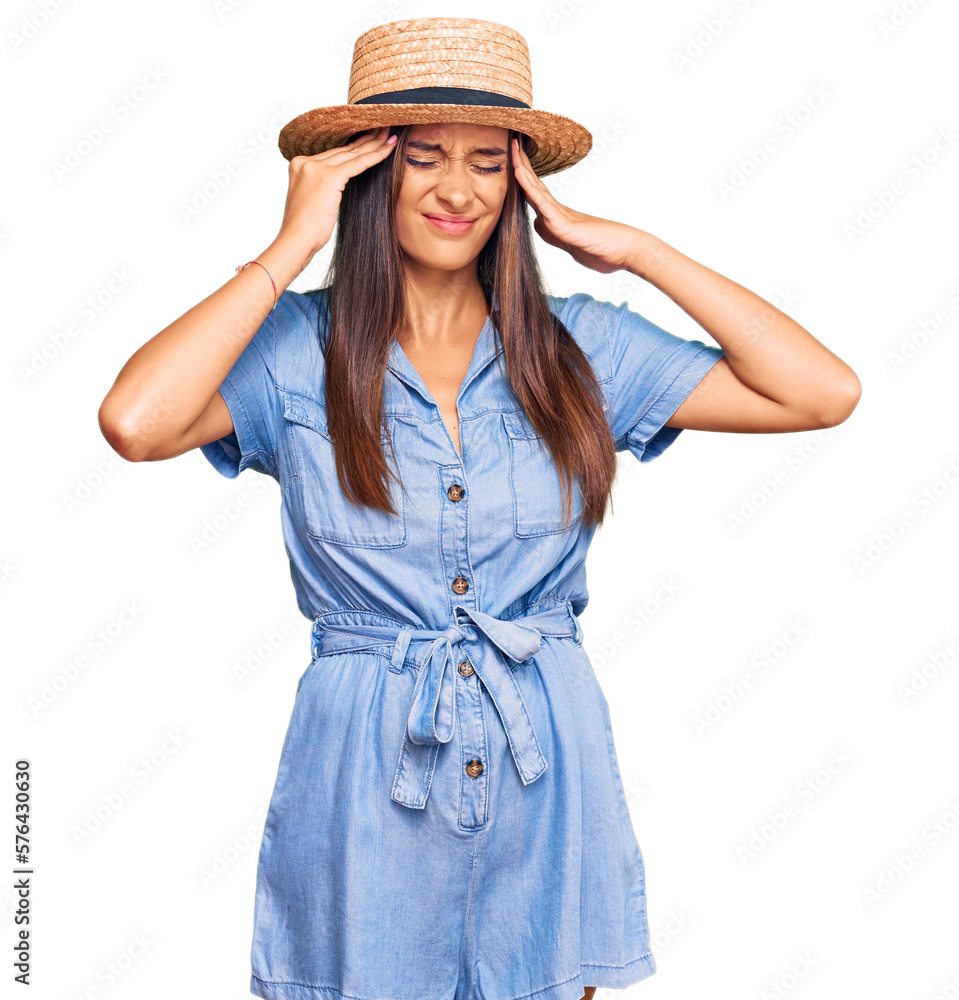 Young hispanic woman wearing summer hat suffering from headache desperate and stressed because pain and migraine. hands on head. Young hispanic woman wearing summer hat suffering from headache desperate and stressed because pain and migraine. hands on head.