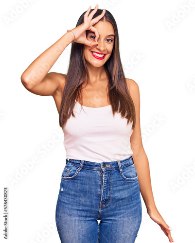 Young hispanic woman wearing casual clothes smiling happy doing ok sign with hand on eye looking through fingers
