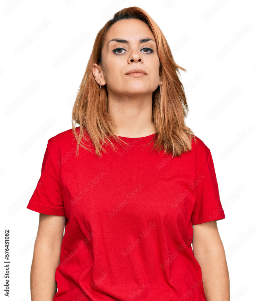 Hispanic young woman wearing casual red t shirt relaxed with serious expression on face. simple and natural looking at the camera. Hispanic young woman wearing casual red t shirt relaxed with serious expression on face. simple and natural looking at the camera.