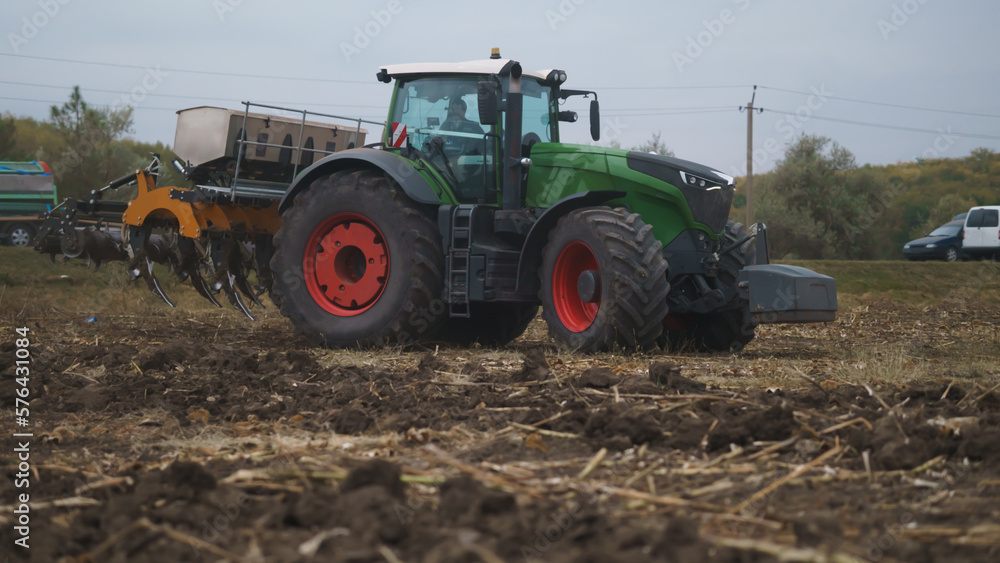 Tractor working in the field. Autumn tillage. Deep ripping with powerful tractor Tractor working in the field. Autumn tillage. Deep ripping with powerful tractor