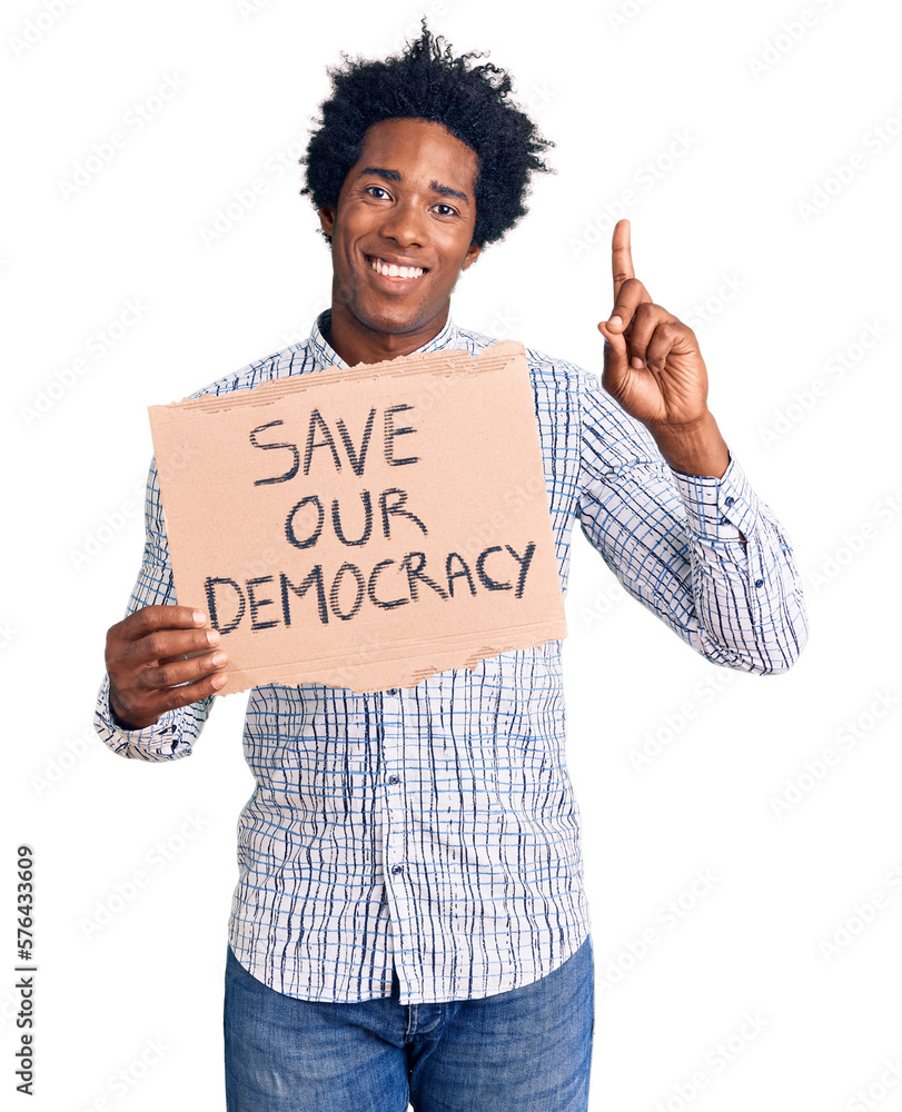 Handsome african american man with afro hair holding save our democracy protest banner surprised with an idea or question pointing finger with happy face, number one Handsome african american man with afro hair holding save our democracy protest banner surprised with an idea or question pointing finger with happy face, number one