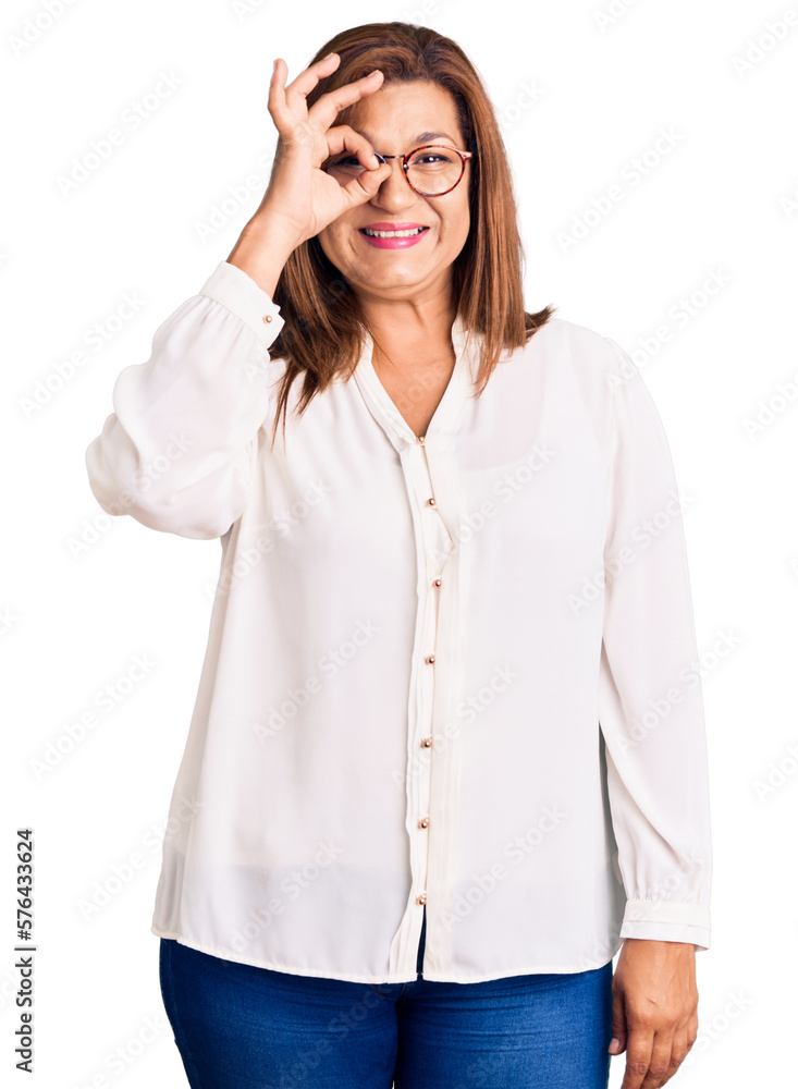 Middle age latin woman wearing casual clothes and glasses doing ok gesture with hand smiling, eye looking through fingers with happy face. Middle age latin woman wearing casual clothes and glasses doing ok gesture with hand smiling, eye looking through fingers with happy face.