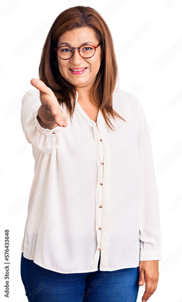 Middle age latin woman wearing casual clothes and glasses smiling friendly offering handshake as greeting and welcoming. successful business. Middle age latin woman wearing casual clothes and glasses smiling friendly offering handshake as greeting and welcoming. successful business.