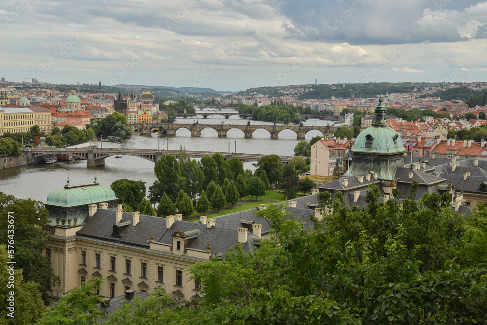 View on Prague city during summer with bridges over the Moldau river and houses, trees and churches, Czech republic.
