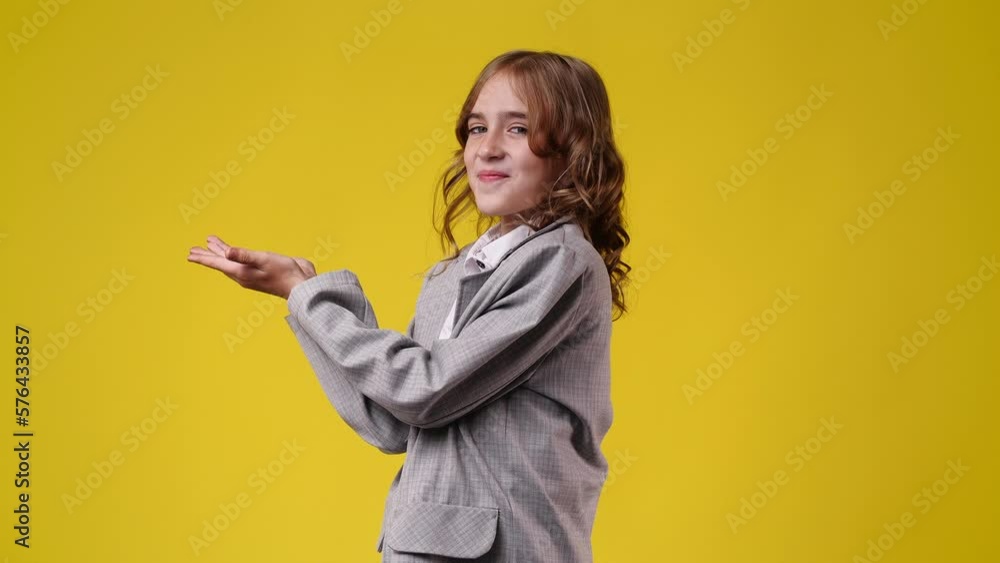 4k video of one girl pointing at left over yellow background. 4k video of one girl pointing at left over yellow background.
