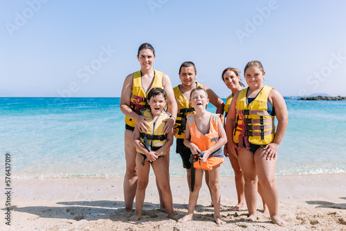Group of cheerful family in swim safety jackets photo