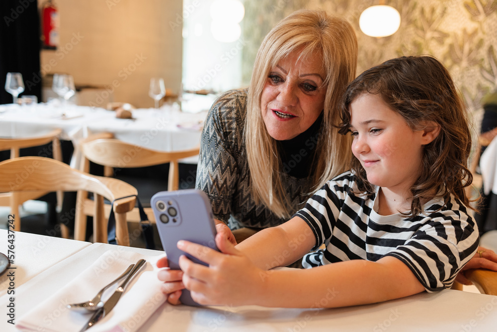 Positive woman and girl taking selfie on smartphone Positive woman and girl taking selfie on smartphone