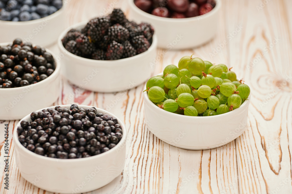 Ripe gooseberries in a white bowl on the table Ripe gooseberries in a white bowl on the table