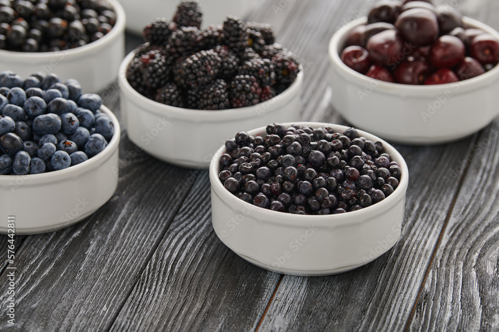 Ripe blueberries, assortment of ripe berries in bowls Ripe blueberries, assortment of ripe berries in bowls
