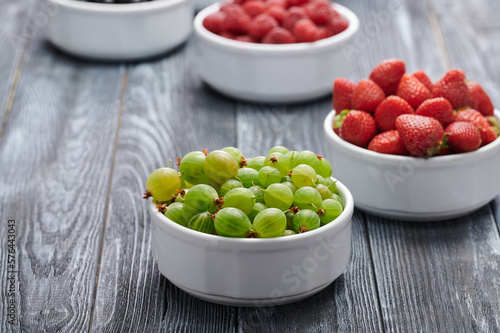Ripe gooseberries in a white bowl on the table