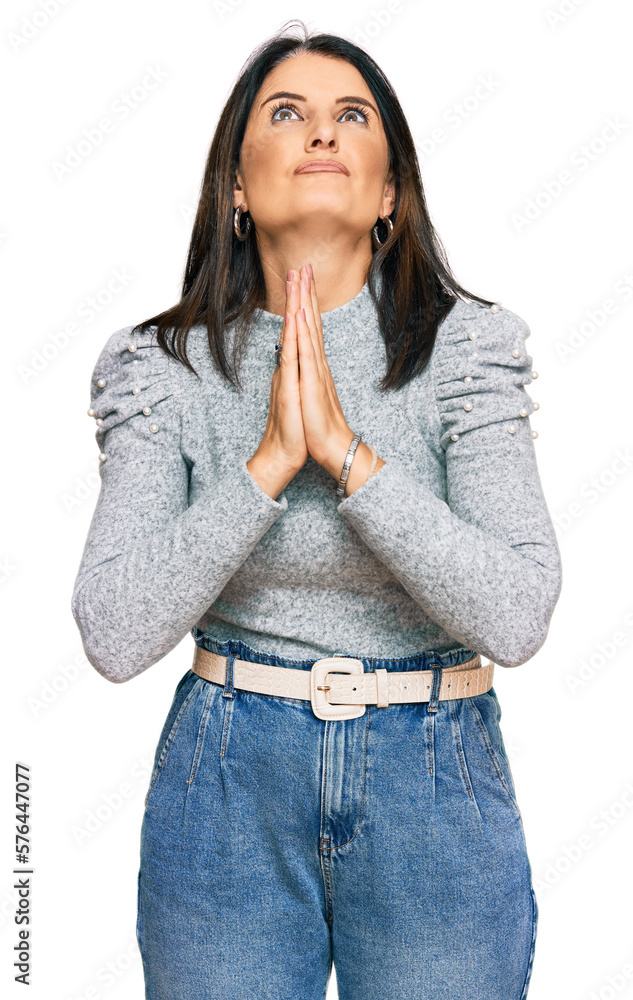 Middle age brunette woman wearing casual clothes begging and praying with hands together with hope expression on face very emotional and worried. begging. Middle age brunette woman wearing casual clothes begging and praying with hands together with hope expression on face very emotional and worried. begging.