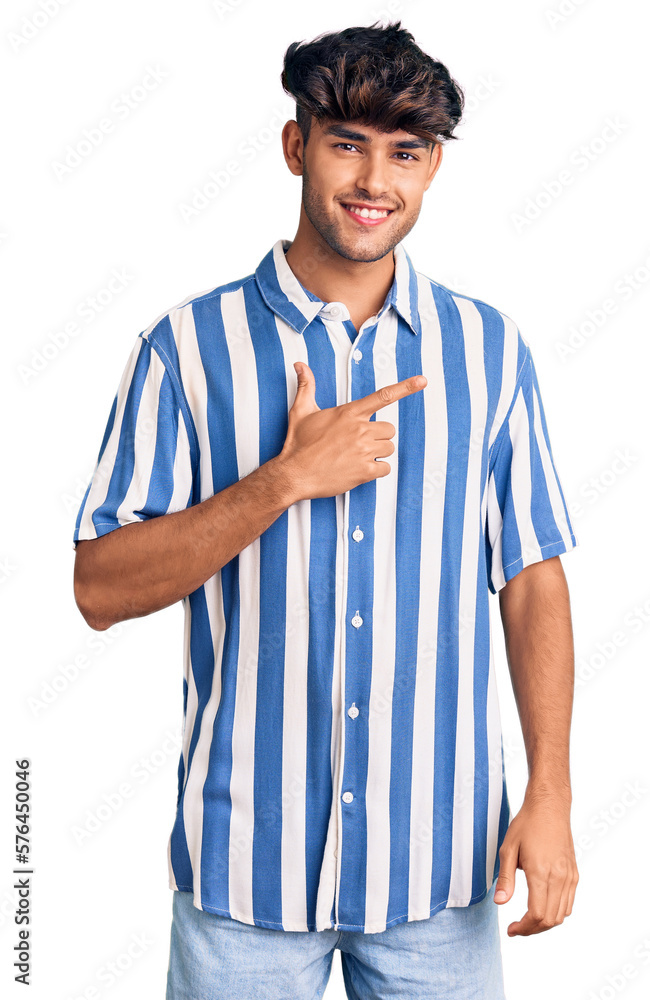 Young hispanic man wearing casual clothes cheerful with a smile on face pointing with hand and finger up to the side with happy and natural expression Young hispanic man wearing casual clothes cheerful with a smile on face pointing with hand and finger up to the side with happy and natural expression
