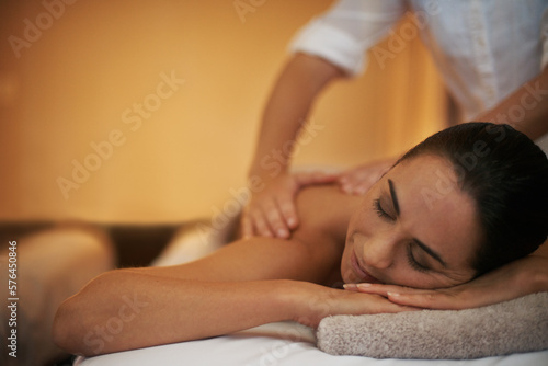 getting rid of those pesky knots. Shot of an attractive woman enjoying a relaxing massage.