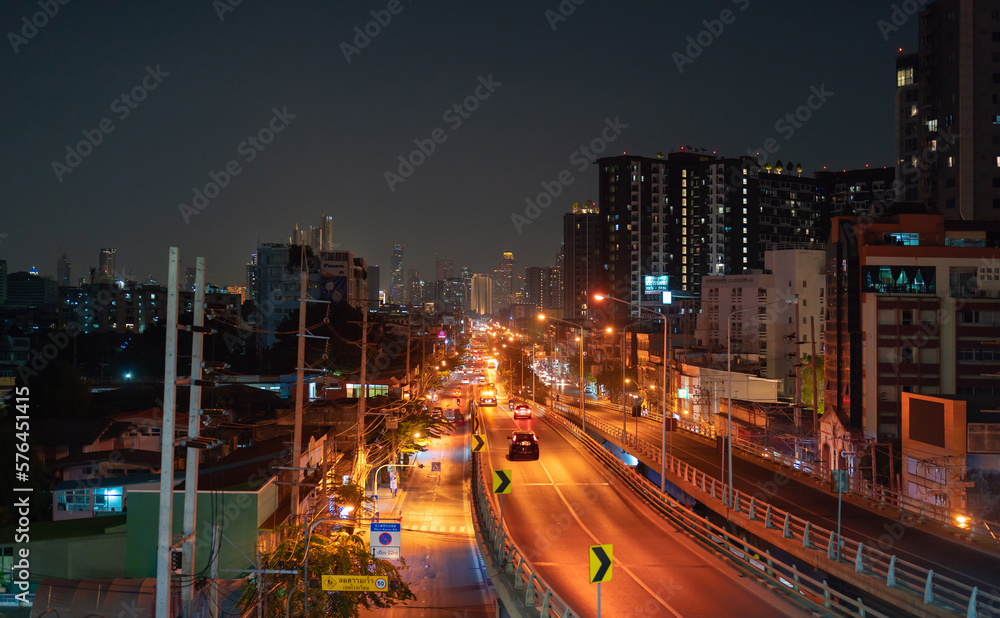 Aerial view of cars driving on highway or moterway. Overpass bridge street roads at night in connection network of architecture concept. Top view. Urban city, Bangkok, Thailand.