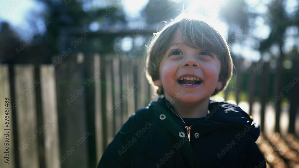 One little boy authentic real life laugh and smile. Happy child face closeup stands outdoors sunny day One little boy authentic real life laugh and smile. Happy child face closeup stands outdoors sunny day