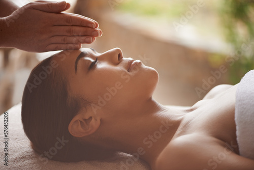 Massaging the body and mind. Shot of a beautiful young woman getting a head massage at a spa.