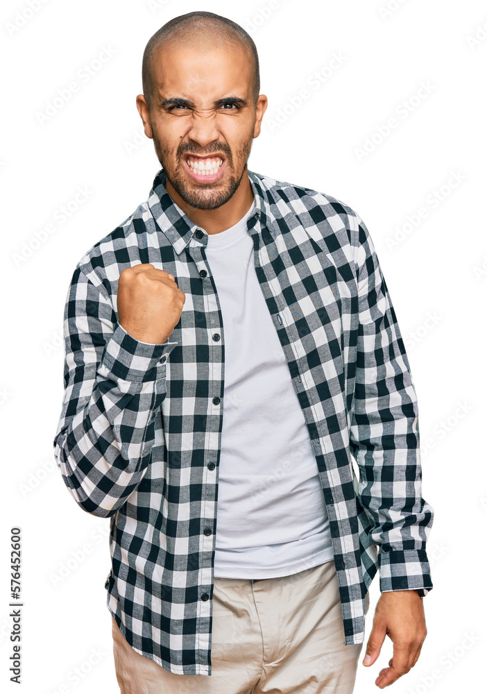 Hispanic adult man wearing casual clothes angry and mad raising fist frustrated and furious while shouting with anger. rage and aggressive concept. Hispanic adult man wearing casual clothes angry and mad raising fist frustrated and furious while shouting with anger. rage and aggressive concept.