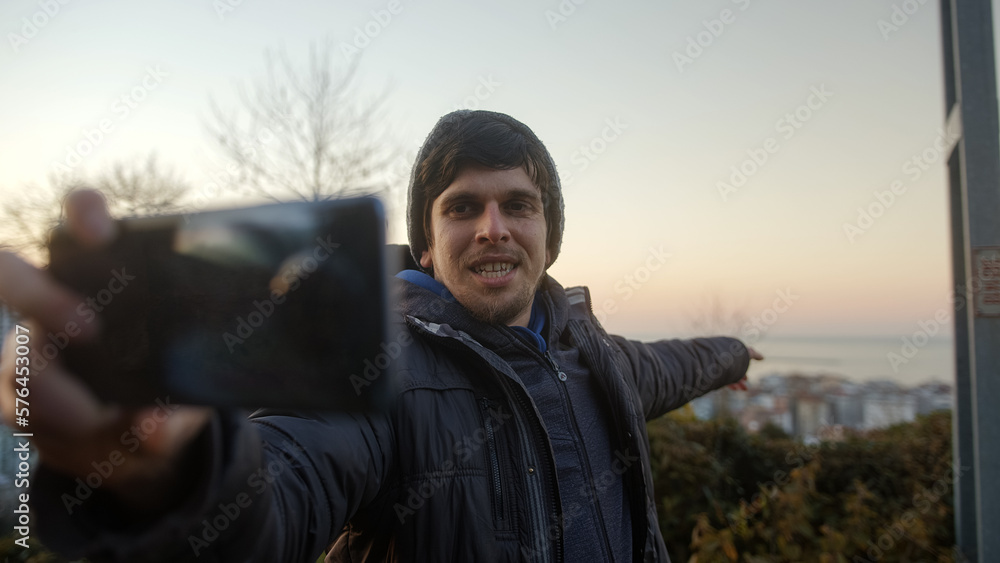 Showing the Beauty of Nature During a Sunset: Handsome Young Man Conducts Video Conference on Phone and Shares Surrounding Wonders with Participants