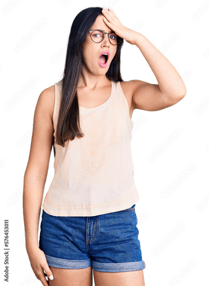 Young beautiful caucasian woman wearing casual clothes and glasses surprised with hand on head for mistake, remember error. forgot, bad memory concept. Young beautiful caucasian woman wearing casual clothes and glasses surprised with hand on head for mistake, remember error. forgot, bad memory concept.