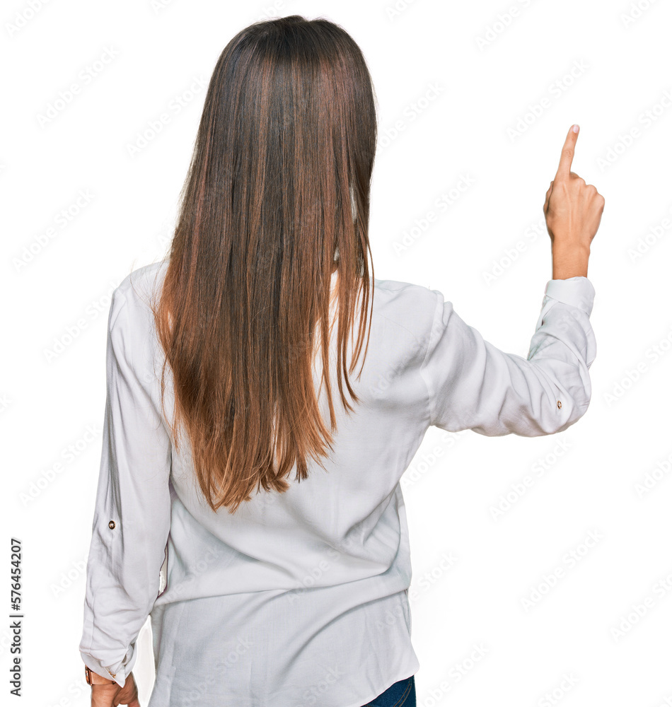 Young beautiful woman wearing casual clothes posing backwards pointing ahead with finger hand Young beautiful woman wearing casual clothes posing backwards pointing ahead with finger hand