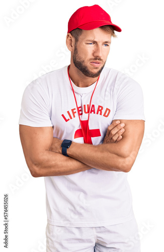 Young caucasian man wearing lifeguard t shirt holding whistle shaking and freezing for winter cold with sad and shock expression on face